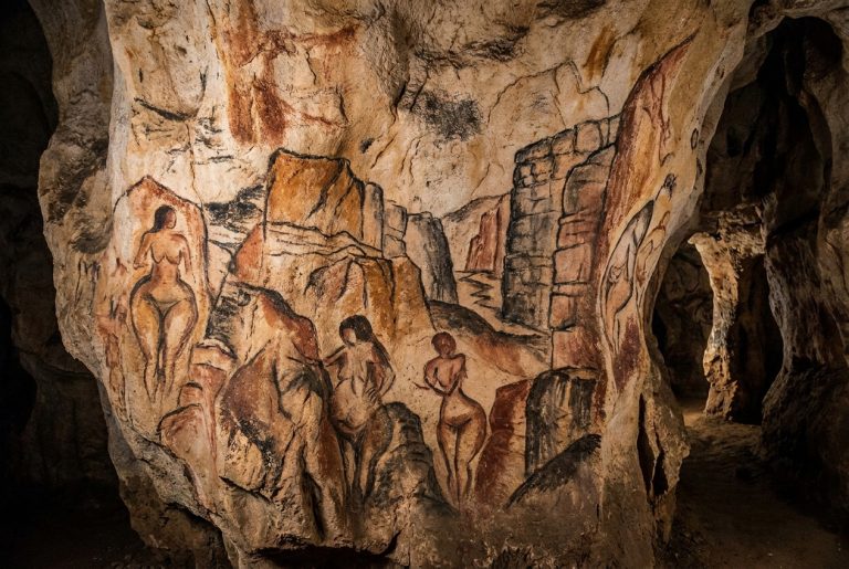 Prehistoric cave painting in the style of Lascaux depicting female figures in a rugged landscape surrounded by imposing stone walls and narrow passages drawn in ochre and charcoal